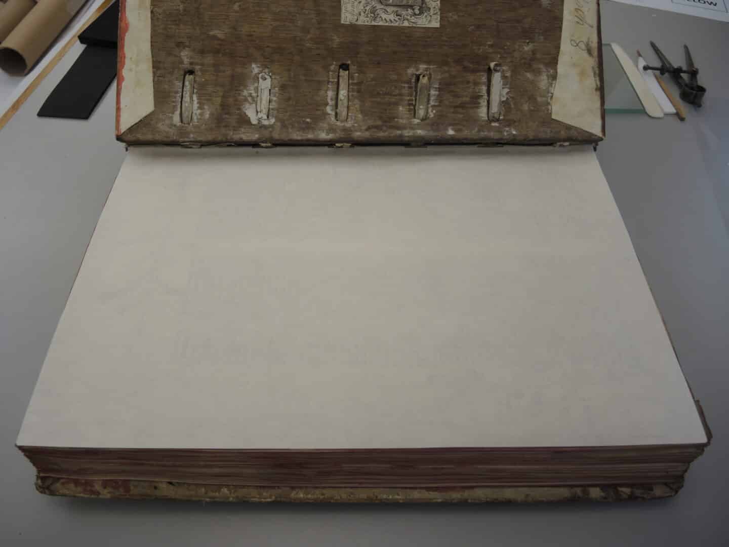 A large open manuscript, the page covered in a protective leaf of Japanese tissue